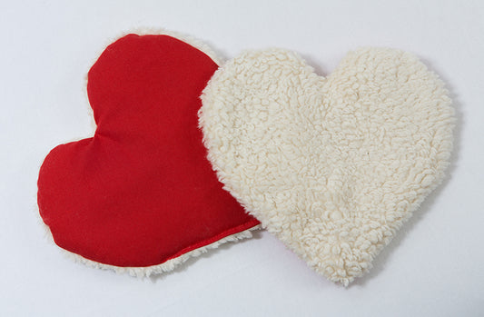 Plüsch-Wärmekissen in Herzform. Das Kissen hat eine Füllung aus Traubenkernen, Rapssamen oder Bio-Hirse.